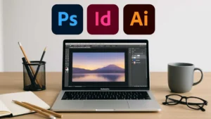 Escritorio minimalista con laptop mostrando Photoshop y logos de Adobe.