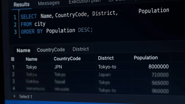 Pantalla de computadora con código SQL y gráficos en una oficina moderna.
