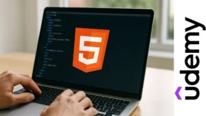 Persona escribiendo en laptop con el logo naranja de HTML en la pantalla, representando aprendizaje inicial en desarrollo web.