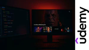Vista dividida con monitor mostrando líneas de código coloridas y pantalla con interfaz tipo Netflix iluminada en tonos rojos y negros.